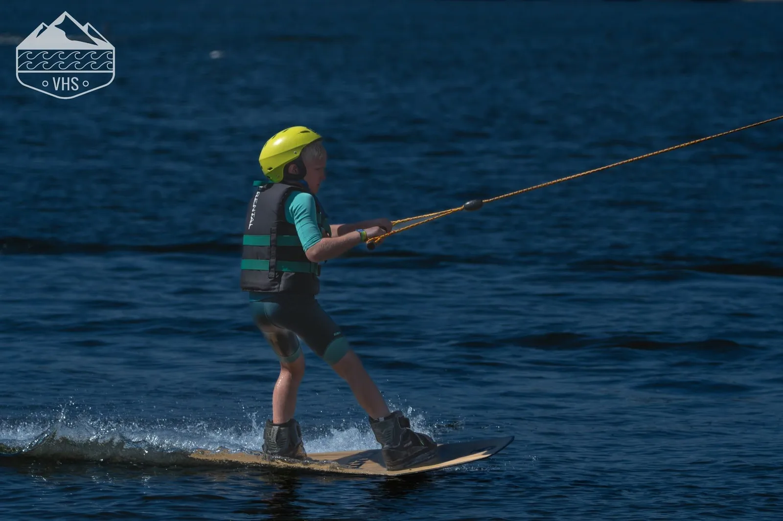 Uczestnik obozu wakeboardowego na jeziorze podczas letnich zajęć