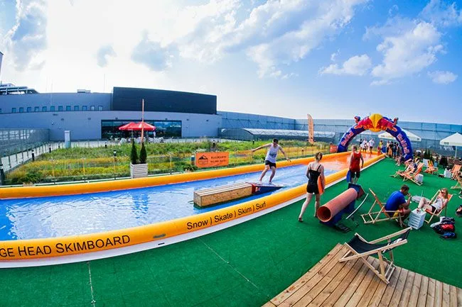 Uczestnik ślizgający się po mobilnym torze skimboardowym podczas plenerowego eventu